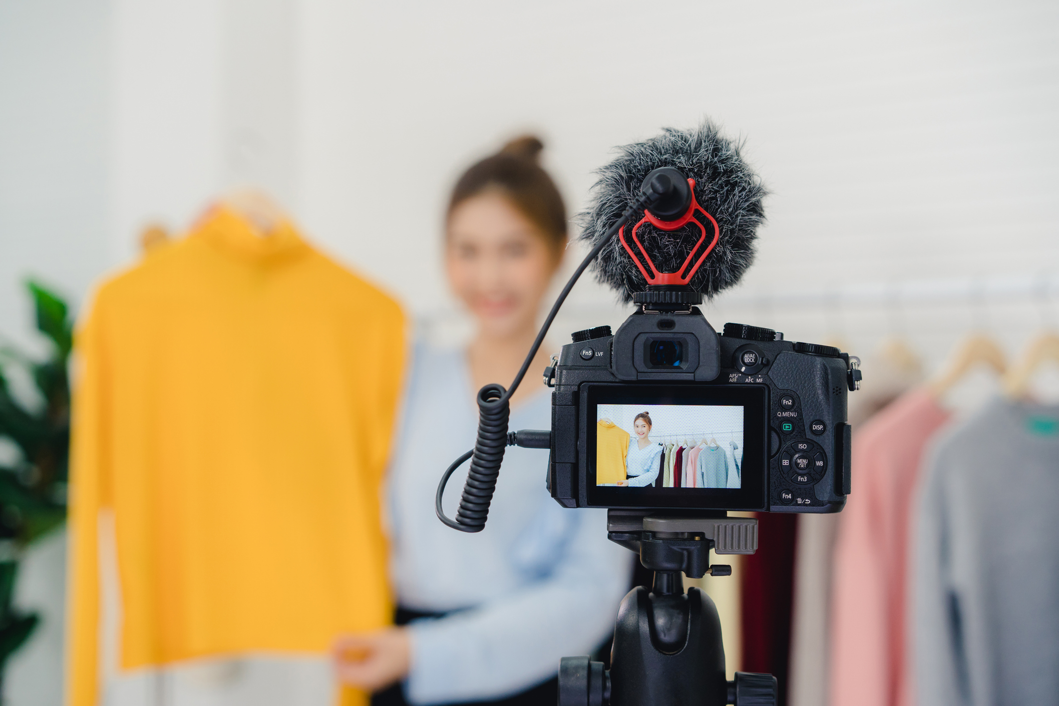 Asian fashion blogger showcasing products in front of video camera