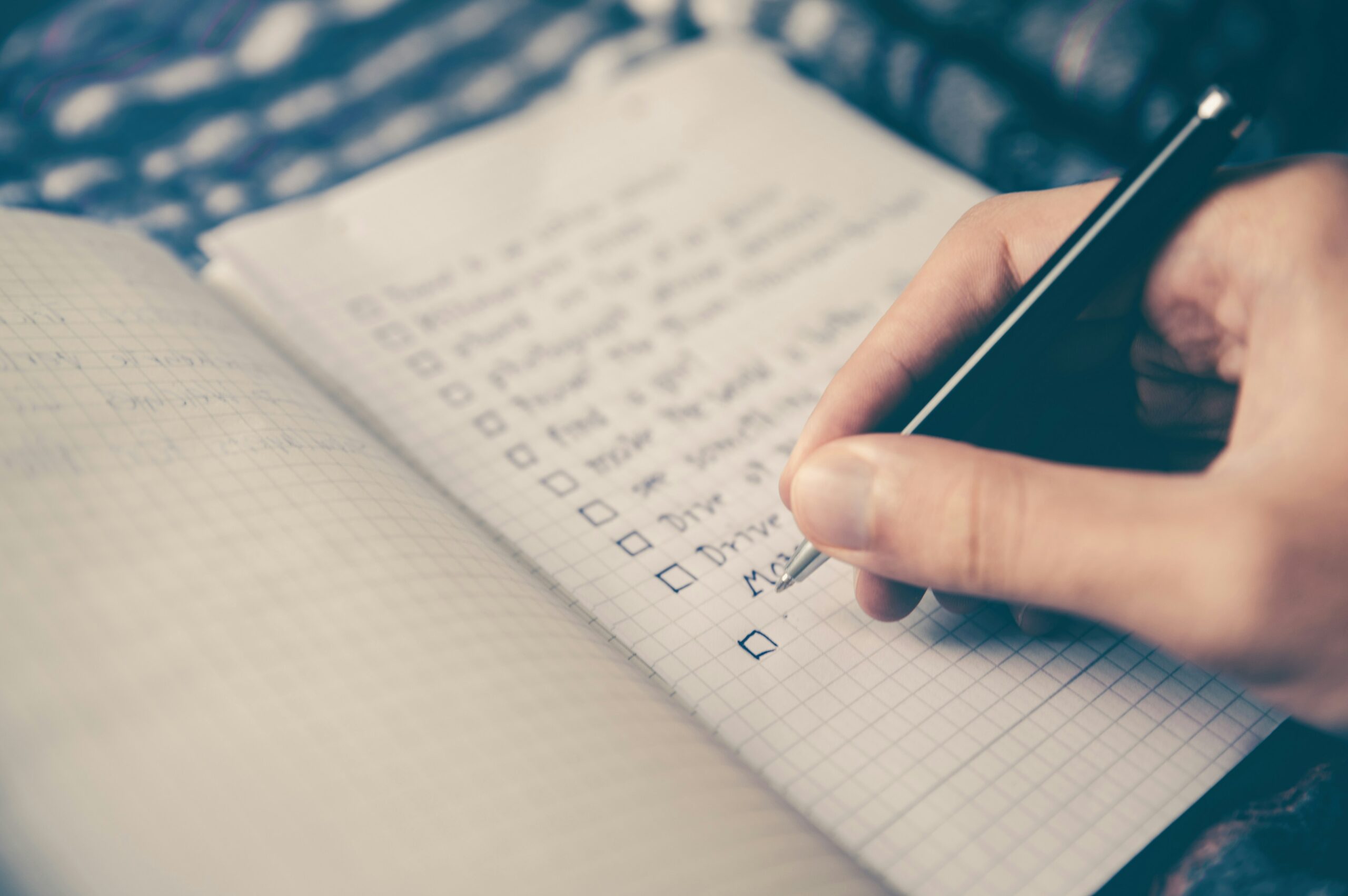 black-friday-ecommerce-checklist-hand holding a pen making a checklist