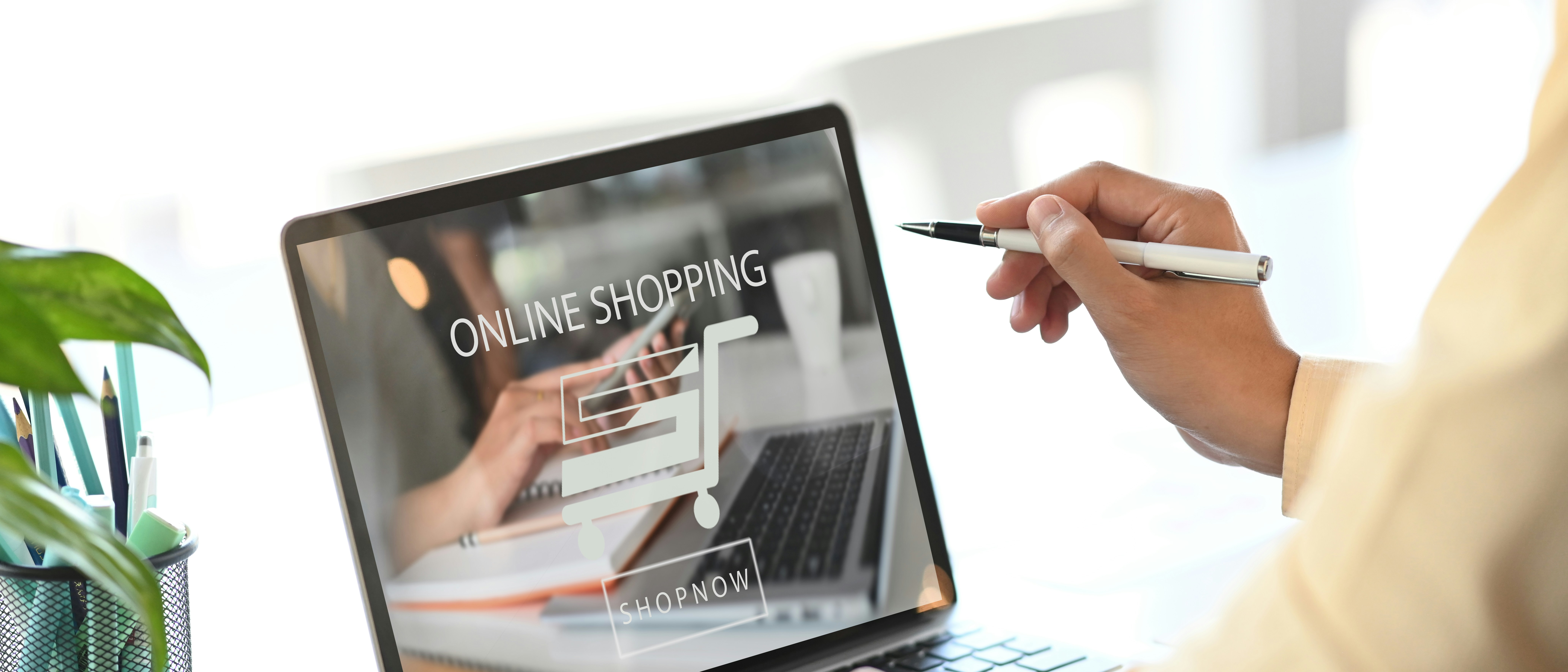 digital-transformation-ecommerce-woman holding a white pen with her laptop on the table